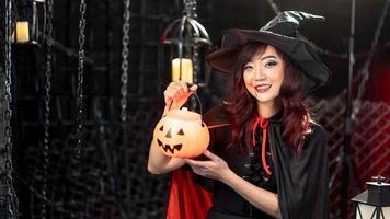 Porträt schöne junge asiatische Frau tragen Halloween-Kostüm hält einen Kürbis in Halloween. Emotion Lächeln foto