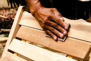 Arbeiten, um Holz zu glätten und mit Schleifpapier zu reinigen foto