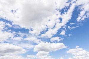 weiße Wolken, die schweben und sich mit einem blauen Himmel im Hintergrund bilden foto