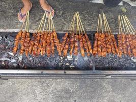 satay. ist ein typisch indonesisches Gericht, das durch Grillen zubereitet wird. isoliert, wenn der Verbrennungsprozess stattfindet foto