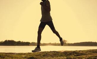 Die Silhouette eines laufenden Mannes trainiert den Abend. foto
