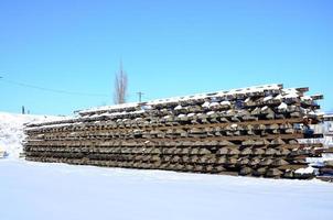 Viele alte Schienen und Schwellen werden im Winter in einem Eisenbahnlager gestapelt. das Konzept, eine abgenutzte Eisenbahnstrecke zu erneuern foto