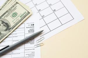 IRS-Formular w-2g bestimmte Glücksspielgewinne liegen mit Stift und vielen Hundert-Dollar-Scheinen auf dem Kalenderblatt foto