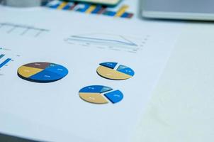 geschäftsdokumente grafiken und diagramme dokumentieren die finanzielle entwicklung, bankkonten, statistiken, auf dem schreibtisch im büro. foto