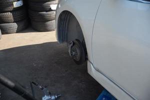 Wechseln Sie einen Autoreifen, der durch eine Reifenpanne verursacht wurde, indem Sie das Auto mit einem Wagenheber anheben. foto