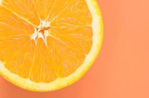Draufsicht auf eine orangefarbene Fruchtscheibe auf hellem Hintergrund in oranger Farbe. ein gesättigtes Zitrustexturbild foto