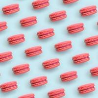 rosa Dessertkuchen Macaron oder Makrone auf trendiger pastellblauer Hintergrundansicht von oben. flache lagemusterzusammensetzung foto