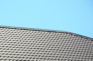 ein Fragment eines Daches aus einem Metallziegel von dunkelroter Farbe. hochwertige Überdachung foto