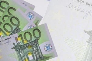 100-Euro-Scheine liegen im Stapel auf dem Hintergrund einer großen halbtransparenten Banknote. abstrakter betriebswirtschaftlicher hintergrund foto