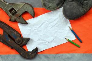 Rollgabelschlüssel mit alten Stiefeln und einem Blatt Papier mit zwei foto