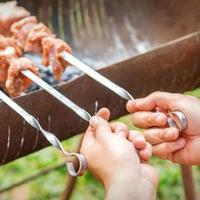 hände des menschen bereiten grillfleisch zu foto