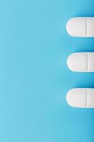 medizinische tabletten in einer reihe auf blauem hintergrund, isolieren. foto