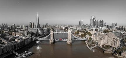 Wunderschönes Schwarz-Weiß-Foto der Londoner Tower Bridge mit einem ikonischen roten Bus, der darauf fährt. foto