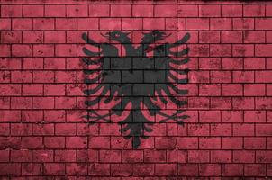 Albanien-Flagge wird auf eine alte Backsteinmauer gemalt foto