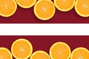 lettland-flagge im horizontalen rahmen der zitrusfruchtscheiben foto