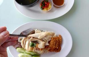 Gedämpfter Reis mit gekochtem Hähnchen auf Löffel, Draufsicht. das beliebteste streetfood in thailand heißt khao mun gai. selektiver Fokus foto