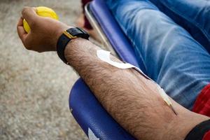 blutspender im blutspendecamp mit einem hüpfball in der hand gehalten im balaji-tempel, vivek vihar, delhi, indien, bild für den weltblutspendetag am 14. juni jedes jahr, blutspendecamp foto