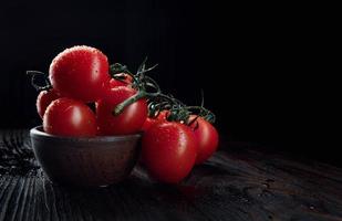 reife rote Tomaten auf dunklem Hintergrund. foto