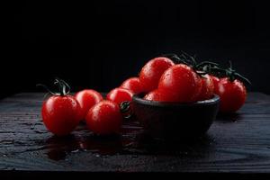 Reife saftige Tomaten auf einem Holztisch. Zweig der roten Tomaten. foto