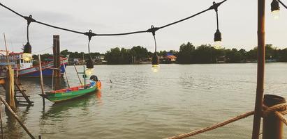 samut sakhon, thailand - 15. juli 2022 grünes langschwanzboot auf dem fluss mit beleuchtung im vordergrund und himmel, grün mit heimathintergrund im vintage-ton. ländlicher lebensstil mit natur- und landschaftsblick.
