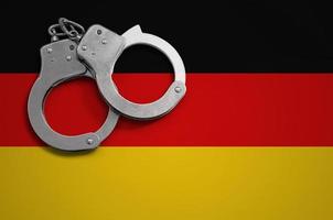 deutschlandfahne und polizeihandschellen. das Konzept der Kriminalität und Straftaten im Land foto