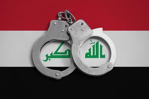 irak-flagge und polizeihandschellen. das Konzept der Einhaltung des Gesetzes im Land und des Schutzes vor Kriminalität foto