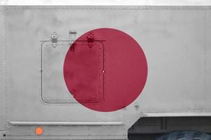 japan-flagge auf seitenteil des militärischen gepanzerten lkw in der nähe abgebildet. konzeptioneller hintergrund der armee foto