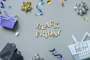 schwarzer freitag-text mit geschenken, einkaufskörben und taschen und festlicher lametta-flachlage foto