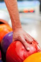 Glückskugel. Nahaufnahme einer Hand, die eine Bowlingkugel hält foto