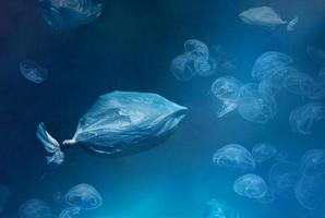 Umwelt- und Meeresverschmutzung, Plastiktüten in Form von ins Meer geworfenen Fischen und Quallen foto