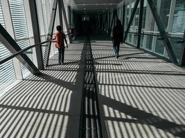 Rückansicht von Menschen, die auf der geschlossenen Fußgängerbrücke spazieren gehen foto