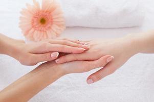 Händepflege. Nahaufnahme des Massagetherapeuten, der die Hände der Kundin massiert foto