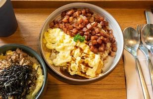 asiatische Fusion aus thailändischer und japanischer Küche, darunter Reis mit Schweinefleisch und Rührei, serviert mit einem Getränk im Restaurant foto