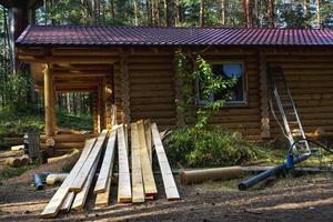 Holzbretter auf der Baustelle eines Holzlandhauses, Bau eines Holzblockhauses, ökologisches Wohnen foto