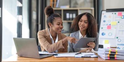 zwei junge asiatische geschäftsfrauen sprechen, beraten, diskutieren die arbeit mit neuen startup-projektideenpräsentationen analysieren planmarketing und investitionen im büro. foto