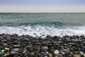 Steinküste des Ozeans mit Wellen foto