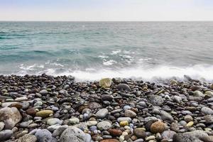 Steinküste des Ozeans mit Wellen foto