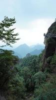 die wunderschönen berglandschaften mit dem grünen wald und der ausgebrochenen felsenklippe als hintergrund in der landschaft des chinas foto