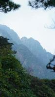 die wunderschönen berglandschaften mit dem grünen wald und der ausgebrochenen felsenklippe als hintergrund in der landschaft des chinas foto