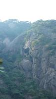 die wunderschönen berglandschaften mit dem grünen wald und der ausgebrochenen felsenklippe als hintergrund in der landschaft des chinas foto