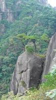 die wunderschönen berglandschaften mit dem grünen wald und der ausgebrochenen felsenklippe als hintergrund in der landschaft des chinas foto