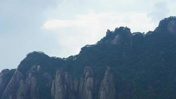 die wunderschönen berglandschaften mit dem grünen wald und der ausgebrochenen felsenklippe als hintergrund in der landschaft des chinas foto