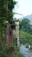 die schönen berglandschaften mit dem grünen wald und dem kleinen dorf als hintergrund in der landschaft des china foto