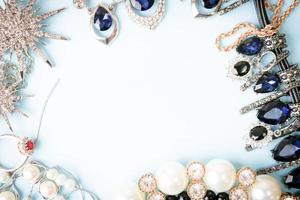 schöner kostbarer glänzender schmuck trendiges glamouröses schmuckset, halskette, ohrringe, ringe, ketten, broschen mit perlen und diamanten auf blauem hintergrund. flache Lage, Draufsicht, Kopierplatz foto