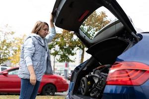 Eine Frau hat einen Kinderwagen in den Kofferraum eines Autos geladen foto