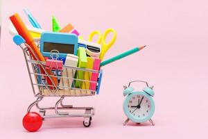 blauer Einkaufswagen oder Trolley und Schreibwaren Stift Bleistift Clip Stift Gummi foto