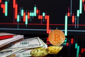 Bitcoin-Kryptowährungen mit Dollar und einer grafischen Anzeige eines Computermonitors im Hintergrund. foto