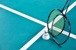 Cremeweißer Badminton-Shuttlecock und Schläger auf dem Boden im Indoor-Badmintonplatz, Kopierraum, weicher und selektiver Fokus auf Federbälle. foto