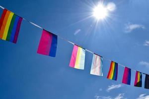 lgbtq-flaggen wurden an einem sonnigen tag an draht gegen den blauen himmel gehängt, weicher und selektiver fokus, konzept für lgbtq-genderfeiern im stolzmonat auf der ganzen welt. foto