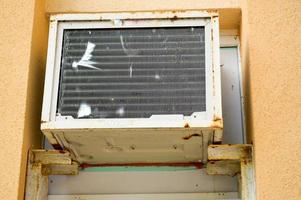 alte schlecht kaputte rechteckige minderwertige rostige klimaanlage zur kühlung der luft im sommer foto